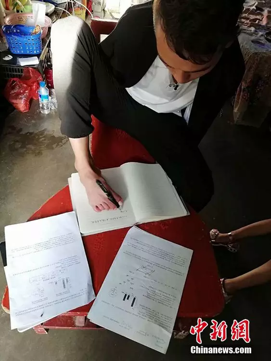 哥哥吴建早用脚写字。巧家县第三中学老师供图